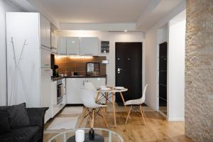 a kitchen and a living room with a table and chairs at Seyra Home Studio - Modern Flat Pool Free Parking Self Check-in in Ştefăneştii de Sus