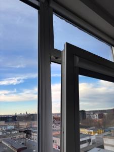 two windows with a view of a city at Cosy Newtown apartment in Vilnius