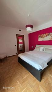 a bedroom with a large bed with a pink wall at Casa Luisa in Recco