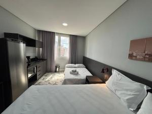 a hotel room with two beds and a television at Town Co - Apartment 1004 in Porto Alegre +20 photos