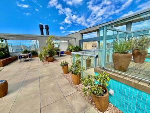 a house with a swimming pool and potted plants at Town Co - Apartment 1004 in Porto Alegre