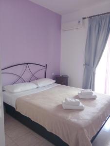 a bedroom with a bed with two towels on it at Hotel Sarandos in Ammouliani