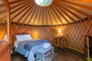 a bedroom in a yurt with a bed and a table at Holly Hideaway in Cullowhee +18 photos