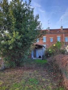 an empty yard with a house and a tree at Maison proche gare in Margny-lès-Compiègne