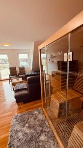 a living room with a black couch and a table at Dachwohnung mit Südbalkon Sauna und Strandkorb in Mühlhausen +3 photos