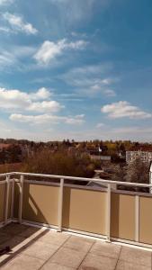 a white fence on a balcony with a view of a city at Dachwohnung mit Südbalkon Sauna und Strandkorb in Mühlhausen