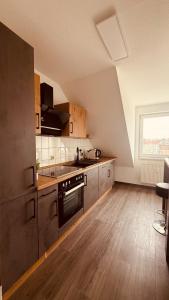 a kitchen with stainless steel appliances and wooden floors at Dachwohnung mit Südbalkon Sauna und Strandkorb in Mühlhausen