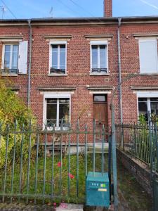 an old brick house with a gate and a fence at Maison proche gare in Margny-lès-Compiègne