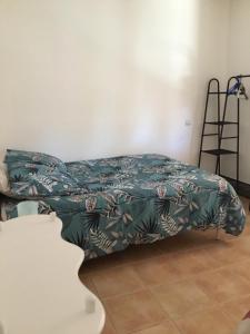 a bed with a green comforter in a room at Marseillan in Marseillan