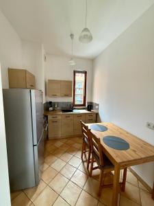 a kitchen with a wooden table and a refrigerator at JustInRent Family Szpitalna 4D-3 in Legnica