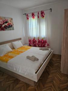 a bedroom with a bed with two towels on it at Apartman Ljubo in Podgora