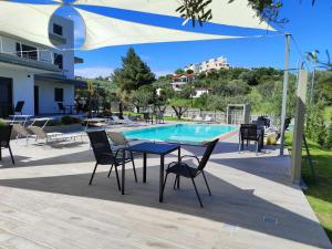 a table and chairs next to a swimming pool at Silia Villas in Ormos Panagias