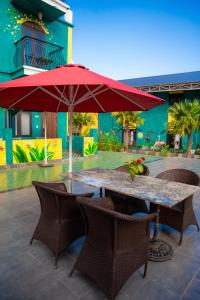 a table and chairs with a red umbrella at Minh Chau Beach Resort in Quang Ninh