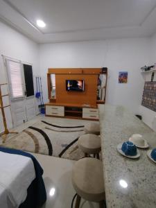 a living room with a bed and a kitchen with a counter at Durmaaquislz in São Luís