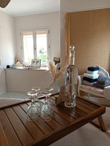 a table with wine glasses and a bottle on it at La parenthèse Brognonnaise in Brognon