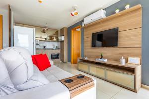 a living room with a white couch and a flat screen tv at Apt conforto 2 suítes Dfplaza in Brasília +20 photos