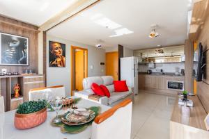 a kitchen and a living room with a couch and a table at Apt conforto 2 suítes Dfplaza in Brasília