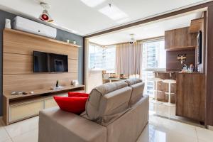 a living room with a couch and a television at Apt conforto 2 suítes Dfplaza in Brasília