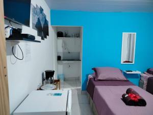 a bedroom with a purple bed and a blue wall at Casa Noronha tropical 2 in Fernando de Noronha
