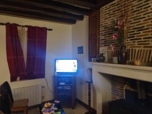 a living room with a tv and a fireplace at BEAUVAL et TRANQUILITE in Veuil