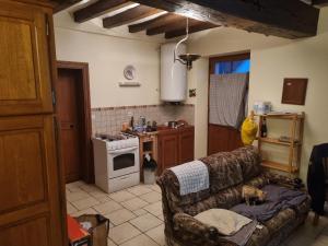 a living room with a couch and a kitchen at BEAUVAL et TRANQUILITE in Veuil