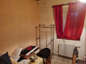 a room with a red curtain and a window at BEAUVAL et TRANQUILITE in Veuil
