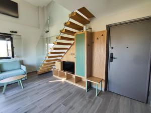 a living room with a staircase and a blue couch at Silia Villas in Ormos Panagias