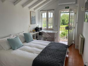 a bedroom with a bed and a desk and a window at Campos Essencia in Arganil