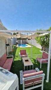 a patio with chairs and a table and a pool at شاليه ياسمين حتا الخاص - Jasmin Hatta Private Chalet in Hatta