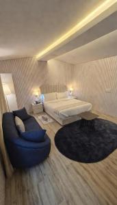 a large bedroom with a bed and a blue couch at شاليه ياسمين حتا الخاص - Jasmin Hatta Private Chalet in Hatta +14 photos