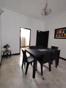 a dining room with a black table and chairs at Del Sol Suites - Apartamento #1 in Guayaquil