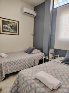 a room with two beds and a window at Del Sol Suites - Apartamento #1 in Guayaquil