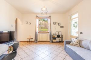 a living room with a couch and a tv at L’Acero Rosso - Giardino privato e Box auto in Menaggio