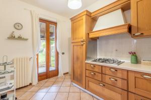 a kitchen with wooden cabinets and a stove at L’Acero Rosso - Giardino privato e Box auto in Menaggio +39 photos