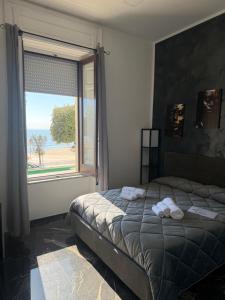 a bedroom with a bed and a large window at Belvedere Lacinio Luxury Rooms Fronte Mare in Crotone
