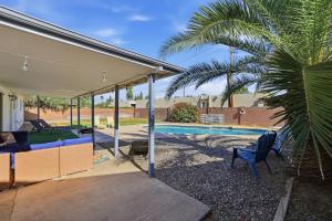 a pavilion with a palm tree next to a swimming pool at Tempe Resort, Pool with Diving Board, 4BR in Tempe