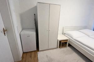 a bedroom with a white cabinet next to a bed at baadenbergerstay A in Cologne