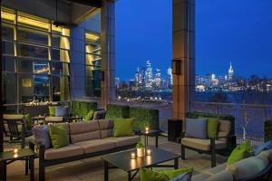 a patio with couches and tables and a view of the city at W Hoboken in Hoboken