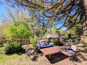 a picnic table and chairs in a yard with a tree at Domaine de la Dordrona in Brantome en Perigord