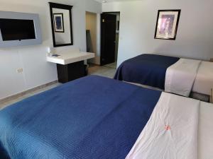 a hotel room with two beds and a sink at Hotel Agora in Ensenada
