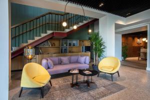a living room with a purple couch and two chairs at Holiday Inn Telavi by IHG in Telavi
