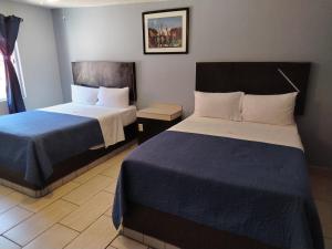 a hotel room with two beds in a room at Hotel Agora in Ensenada