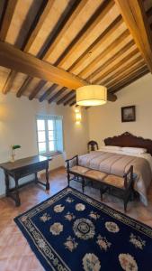 a bedroom with a bed and a bench and a table at Antico Casale Mevania in Bevagna