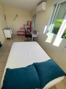 a large bed in a room with a window at Versant Caraïbes in Gourbeyre