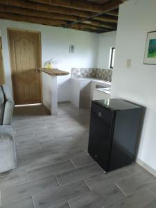 a kitchen with a black refrigerator and a counter at Hospedaje Finca Eje Cafetero, Casa Ne u in Marsella