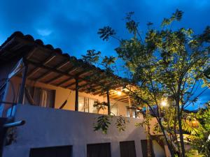 a house with a white wall and trees at Hospedaje Finca Eje Cafetero, Casa Ne u in Marsella