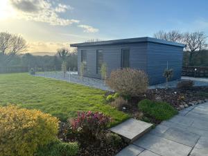 a small house in a yard with a garden at Heron's Rest Studio in Macroom