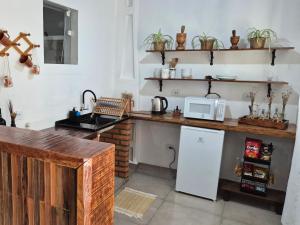 a kitchen with a counter with a microwave and a sink at Pousada da Aline in Sete Barras +32 photos