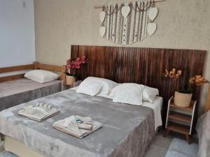 a bedroom with two beds with towels on them at Pousada da Aline in Sete Barras
