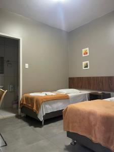 a bedroom with two beds and a shower in it at Hotel Casimiro in Ponta Grossa +33 photos